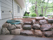 A little creativity & boulder selection provides beautiful access to raised garden and water faucet.